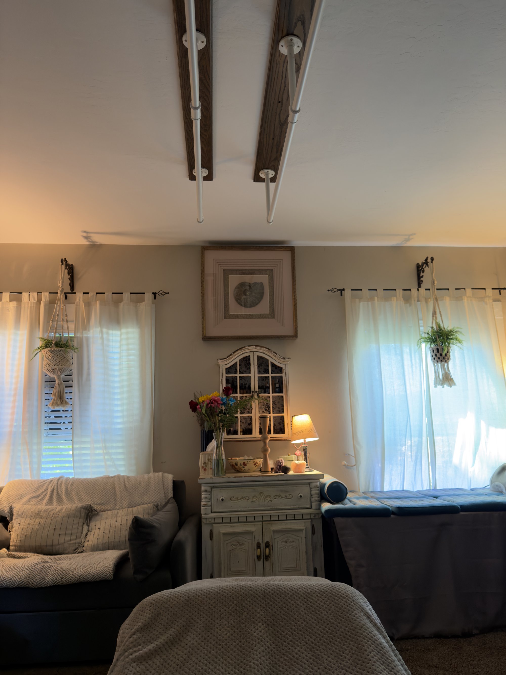 Shabby-chic white vanity with an amber Tiffany lamp glowing among candles and oils